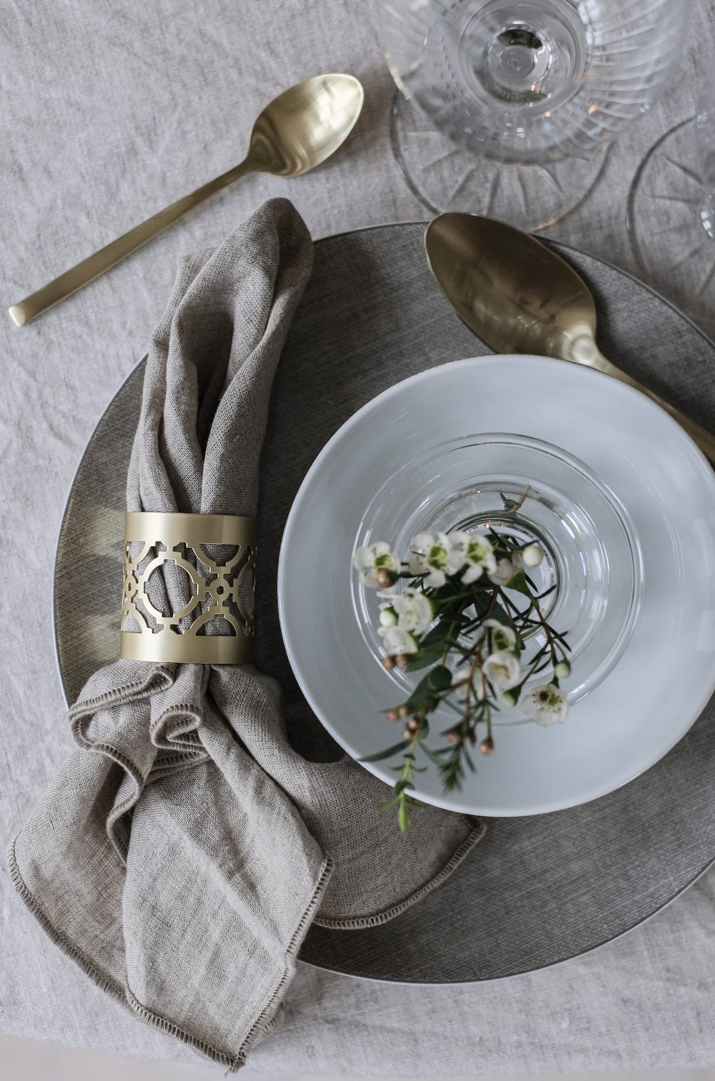Magnor Cape serviettring sammen med t&oslash;yserviett og Magnor Linen tallerkener p&aring; et dekket bord.