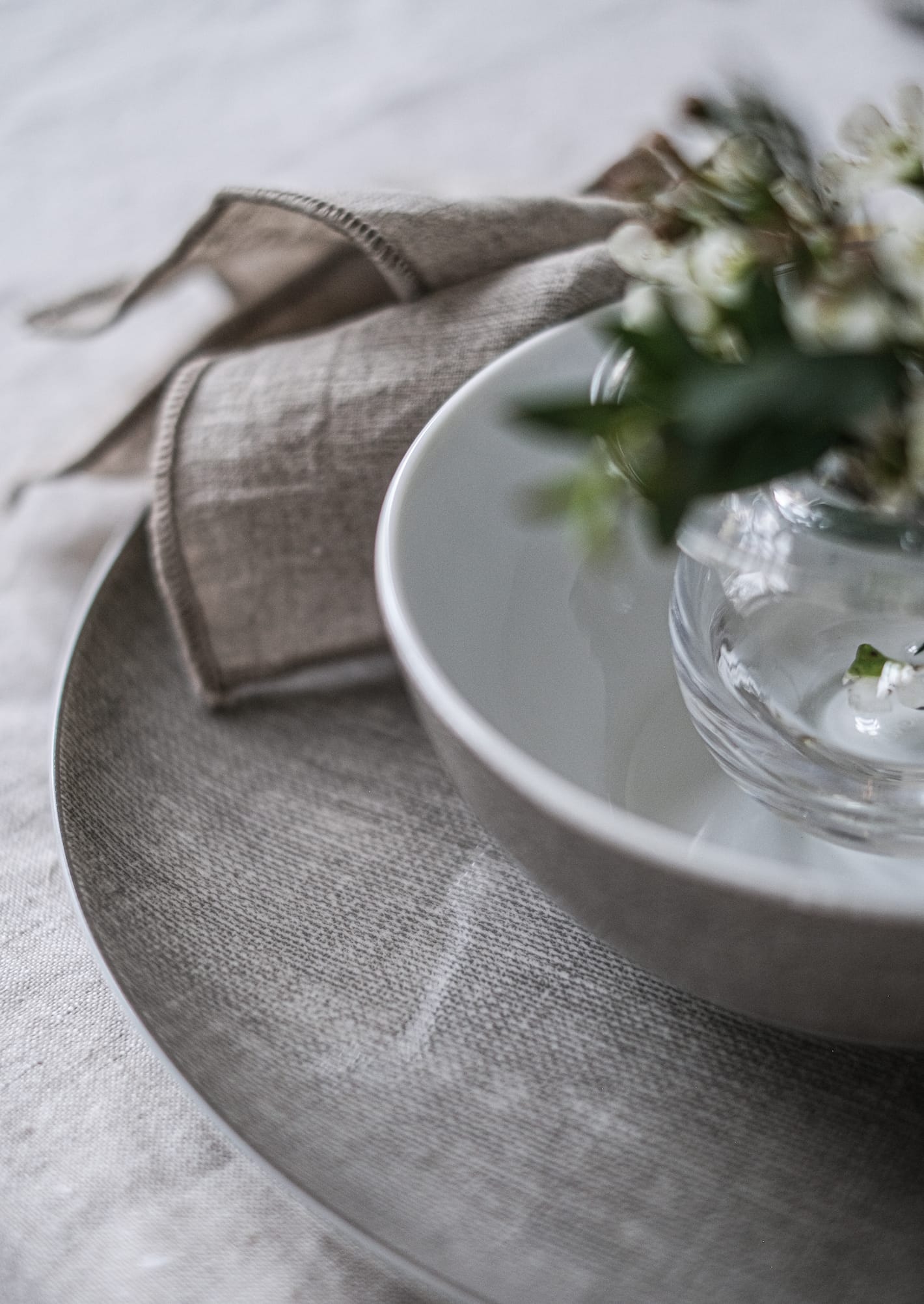 Magnor Linen tallerkener p&aring; et dekket bord.