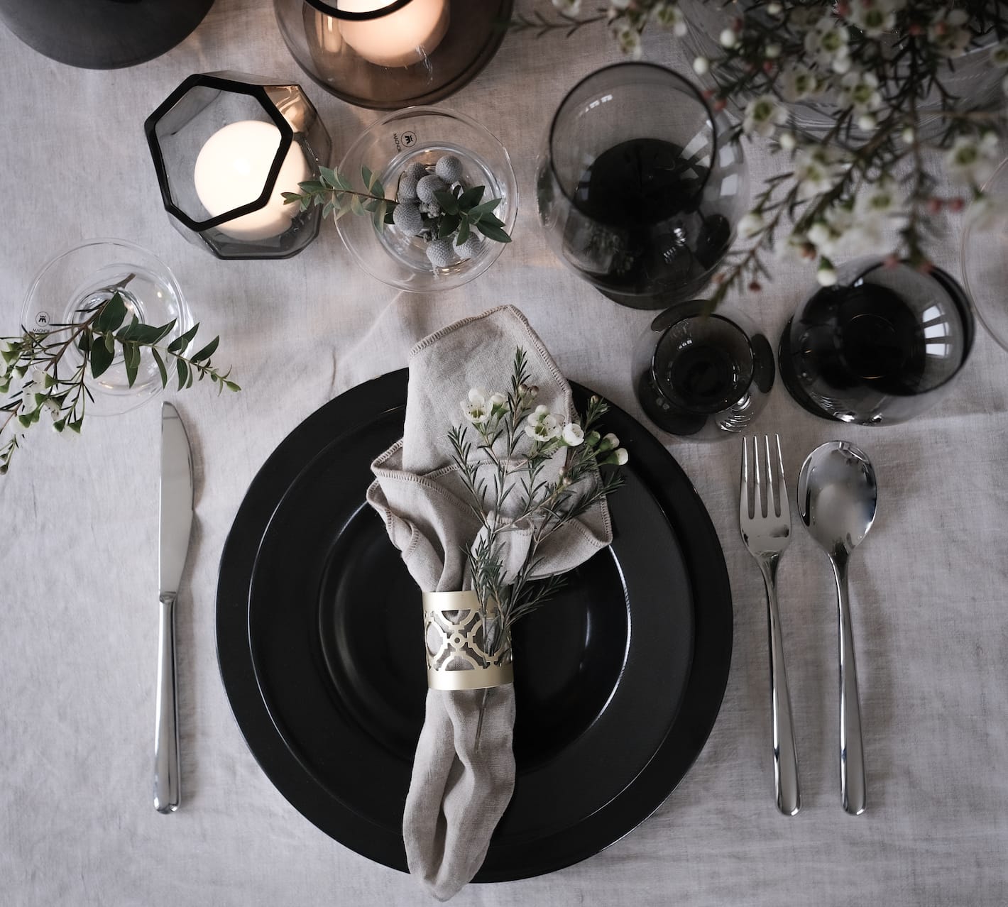 Et bord dekket med servise, glass og pynt i serien Noir fra Magnor.