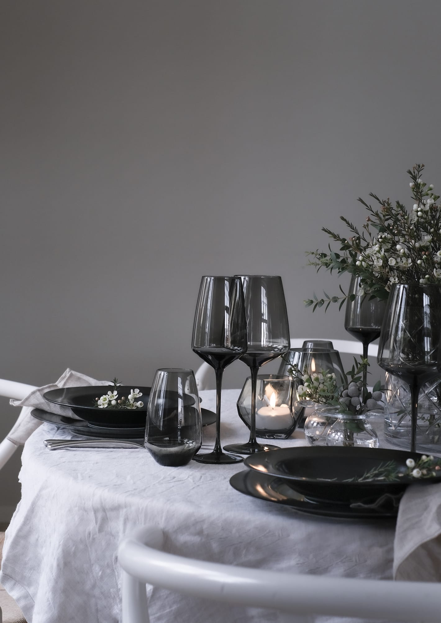 Et bord dekket med servise, glass og pynt i serien Noir fra Magnor.