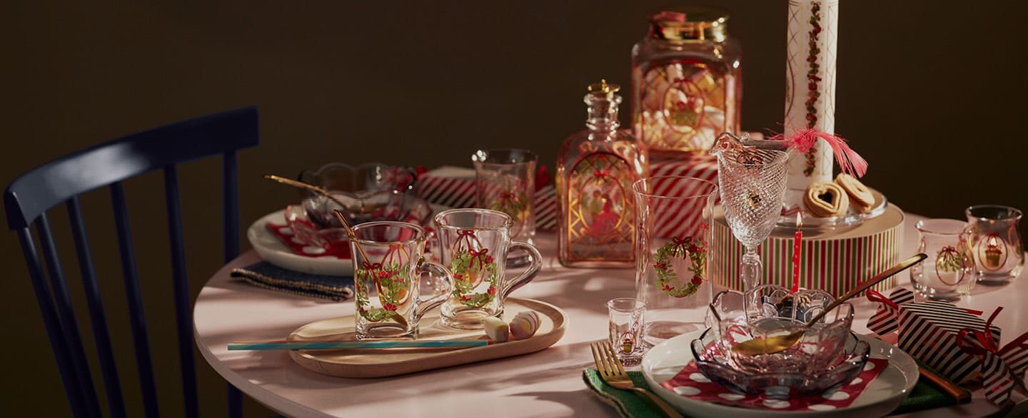 Bord dekket med julepynt og glass fra Holmegaard.