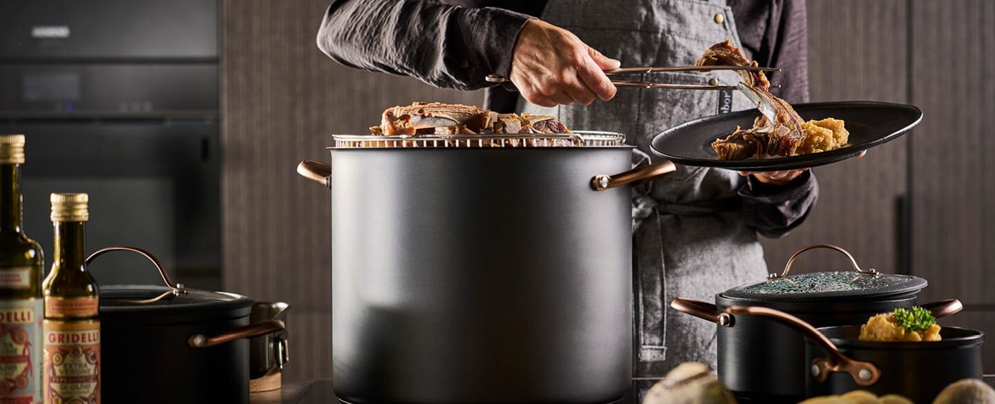 En mann serverer pinnekjøtt fra en Black Copper-gryte.